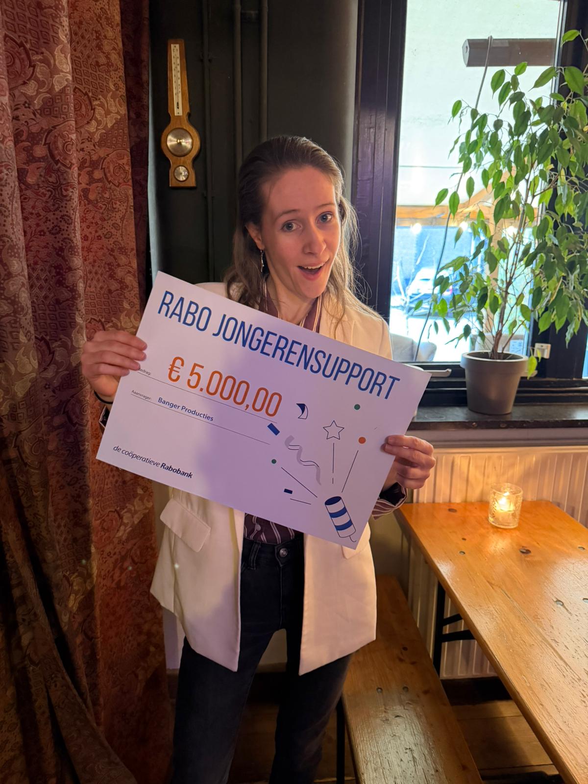 Lisa, samen met Valentijn, met de cheque van Rabobank Jongerensupport